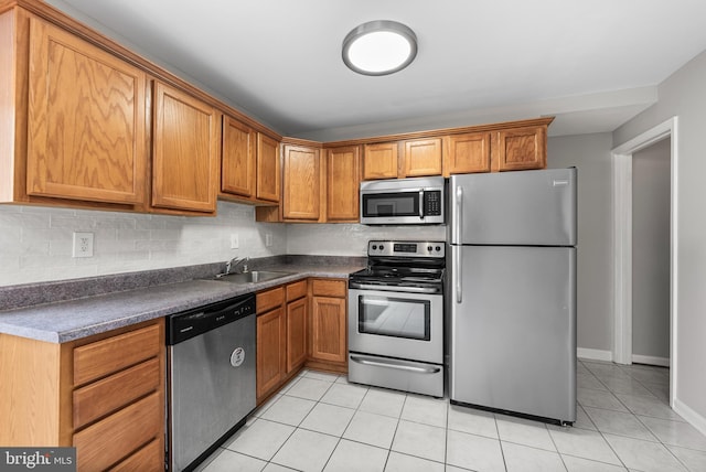 kitchen featuring tasteful backsplash, appliances with stainless steel finishes, sink, and light tile patterned floors