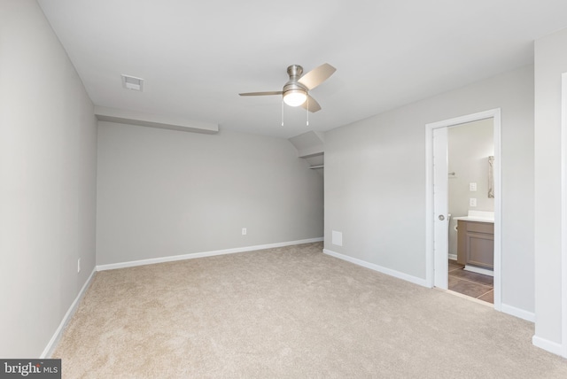 unfurnished bedroom featuring light carpet, ceiling fan, and ensuite bathroom