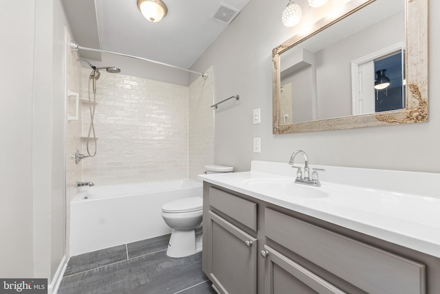 full bathroom with vanity, tiled shower / bath, and toilet