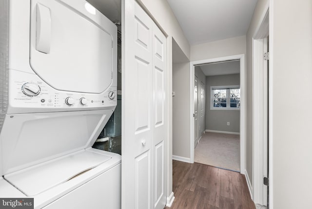 washroom featuring stacked washer / dryer and dark hardwood / wood-style flooring