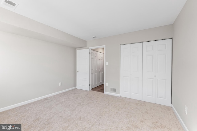 unfurnished bedroom featuring carpet flooring and a closet