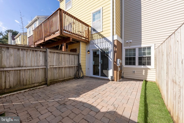 back of property with a wooden deck and a patio area