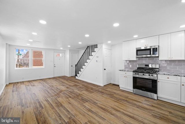 kitchen featuring hardwood / wood-style floors, white cabinets, and stainless steel appliances