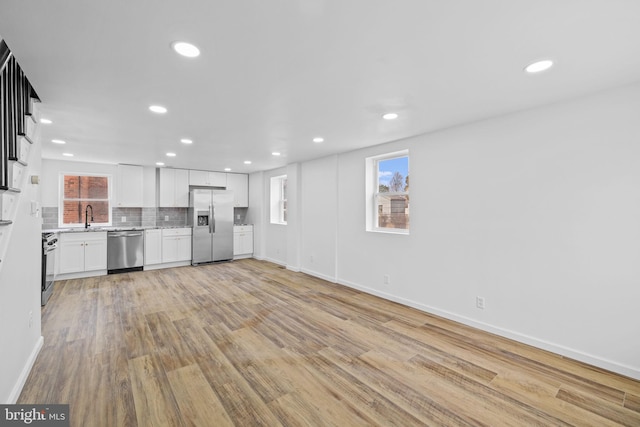 unfurnished living room with light wood-type flooring and sink