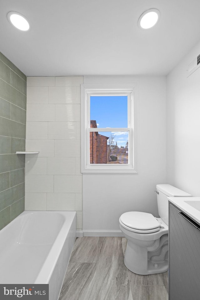 full bathroom featuring toilet, vanity, and  shower combination