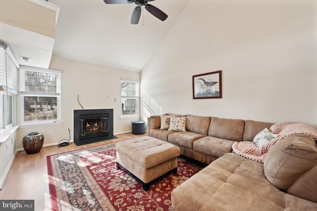 living room featuring wood-type flooring, high vaulted ceiling, and ceiling fan