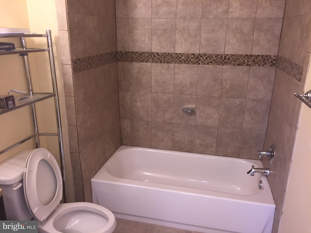 bathroom with toilet and tiled shower / bath