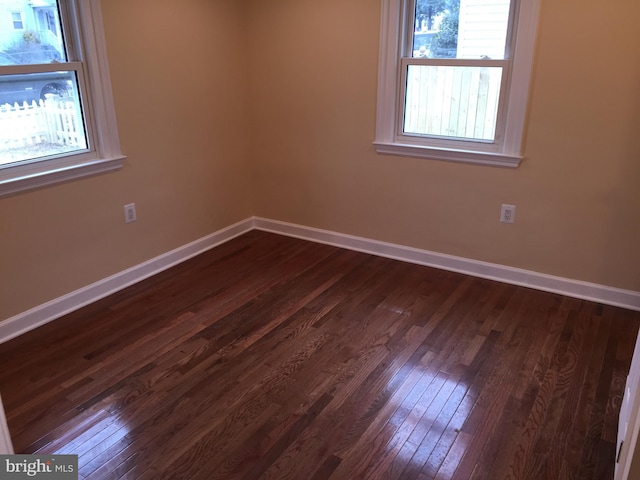 unfurnished room with a wealth of natural light and dark hardwood / wood-style flooring