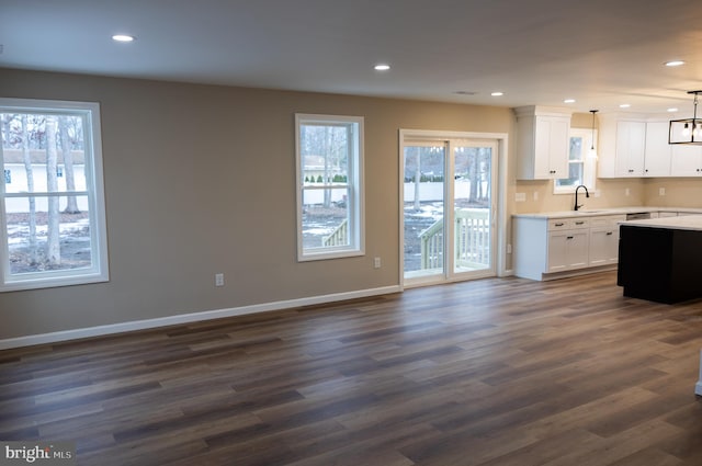 kitchen with white cabinetry, sink, dark hardwood / wood-style floors, and decorative light fixtures