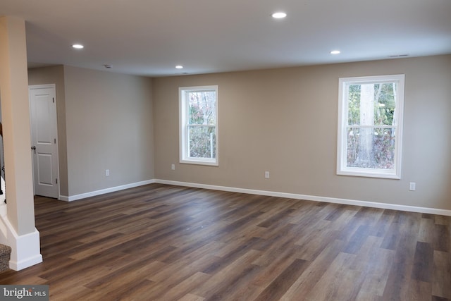 spare room with plenty of natural light and dark hardwood / wood-style flooring