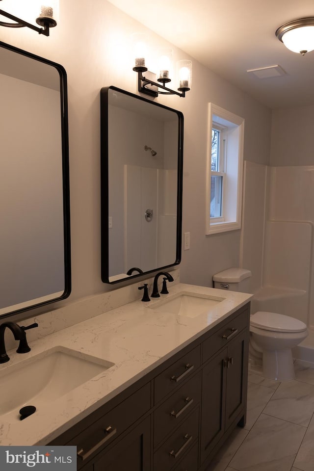 bathroom with a shower, toilet, and vanity