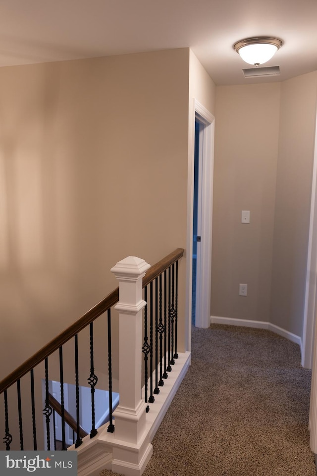 hallway with dark colored carpet