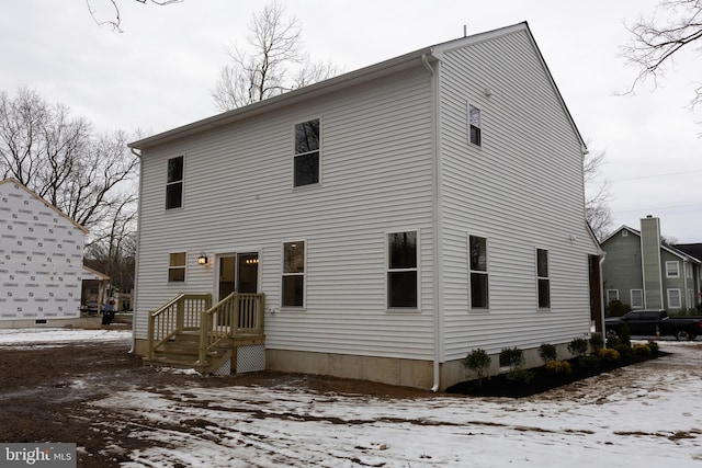 view of snow covered rear of property