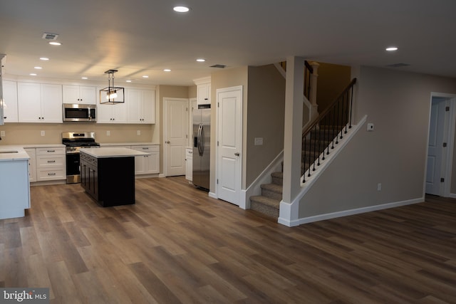 kitchen with white cabinetry, pendant lighting, stainless steel appliances, and a kitchen island