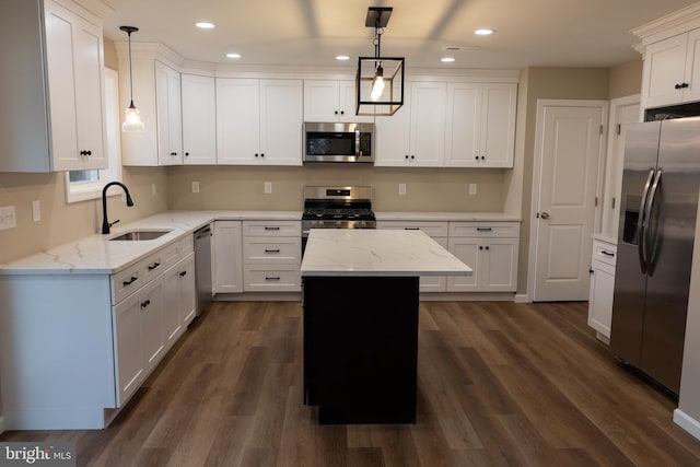 kitchen with light stone countertops, pendant lighting, a center island, stainless steel appliances, and sink