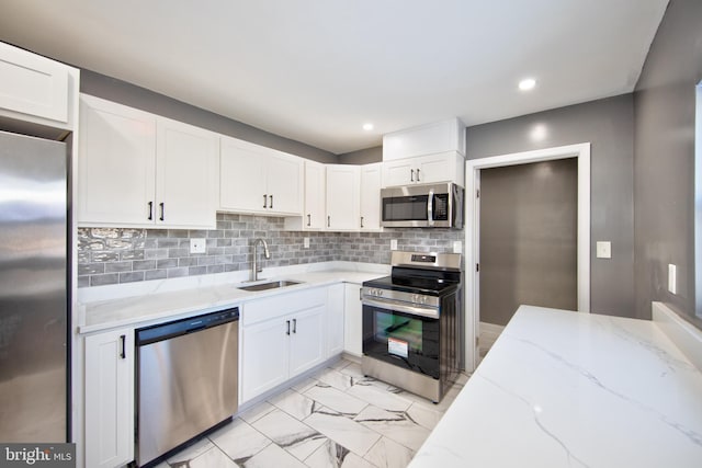 kitchen featuring light stone countertops, sink, white cabinetry, and appliances with stainless steel finishes