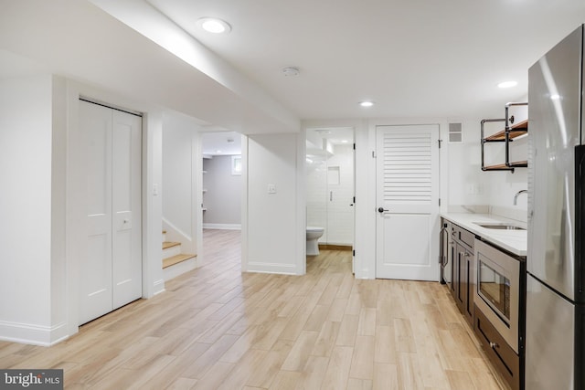 interior space with sink, light wood-type flooring, and stainless steel appliances