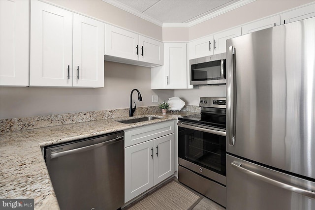 kitchen featuring white cabinetry, sink, ornamental molding, and stainless steel appliances