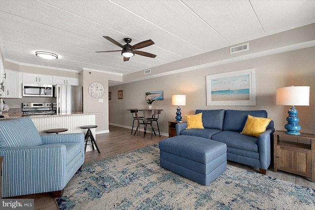 living room featuring ceiling fan and dark hardwood / wood-style flooring