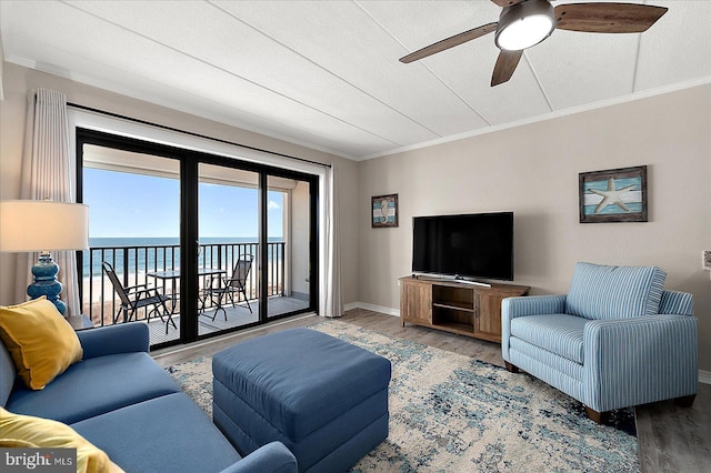 living room with wood-type flooring, a textured ceiling, ceiling fan, and crown molding