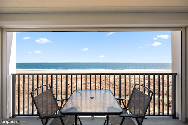 balcony featuring a water view and a view of the beach