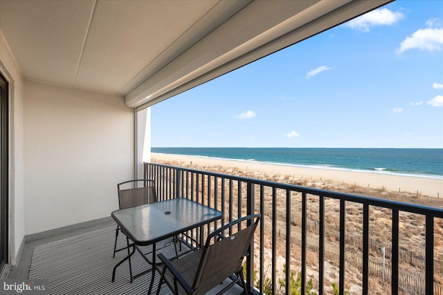 balcony featuring a water view and a beach view