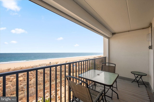 balcony featuring a water view and a beach view