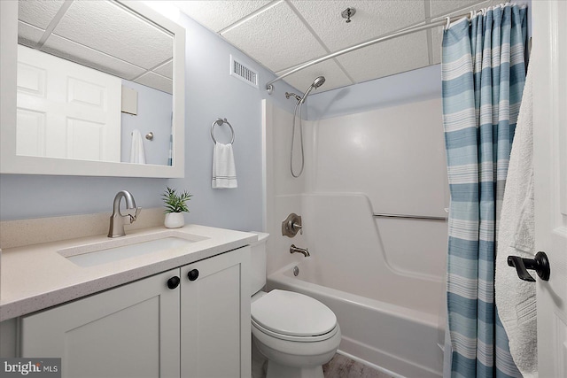 full bathroom with shower / bathtub combination with curtain, vanity, a paneled ceiling, and toilet