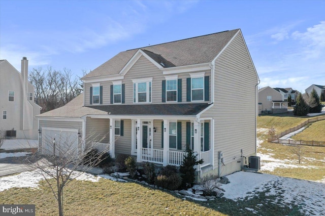 view of front of property with a garage, central AC, a front yard, and covered porch