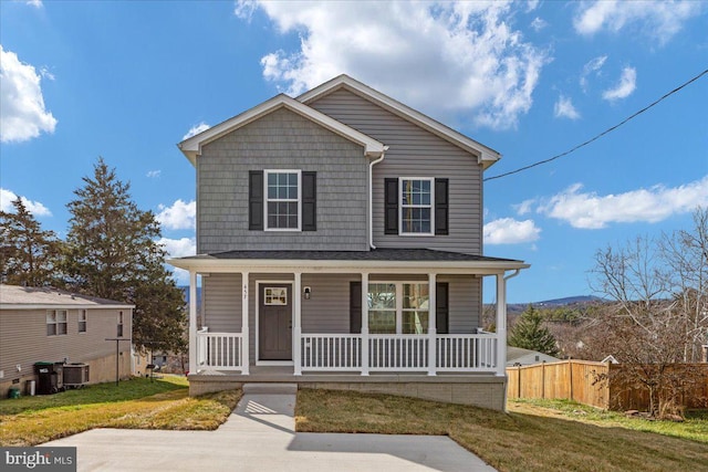 front of property with cooling unit, a front lawn, and covered porch