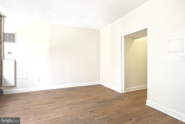 spare room with dark hardwood / wood-style flooring and a textured ceiling