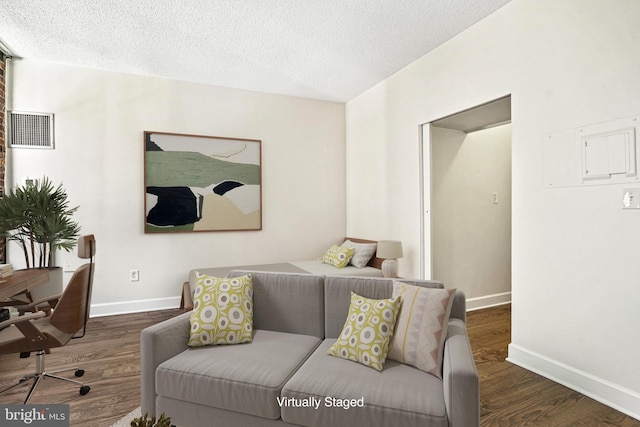 living room featuring dark hardwood / wood-style floors and a textured ceiling