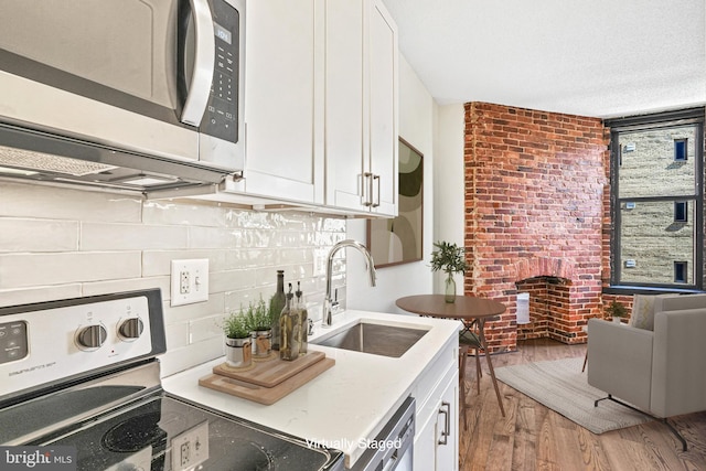 kitchen featuring sink, hardwood / wood-style flooring, white cabinets, and stainless steel appliances