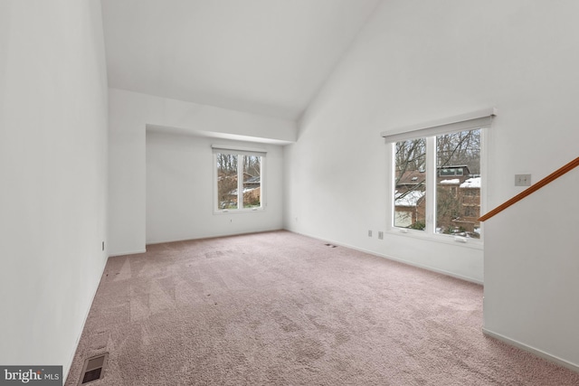 interior space with carpet and high vaulted ceiling