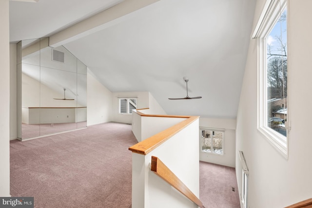 additional living space with ceiling fan, light colored carpet, and lofted ceiling with beams