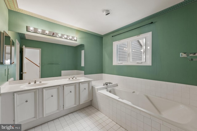 bathroom with tiled tub, vanity, and tile patterned flooring