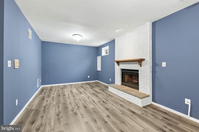 unfurnished living room with a fireplace and light hardwood / wood-style floors