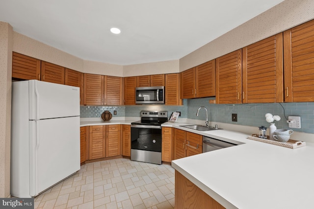 kitchen with sink, appliances with stainless steel finishes, kitchen peninsula, and tasteful backsplash