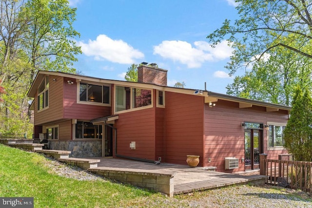 rear view of property featuring an AC wall unit and a patio