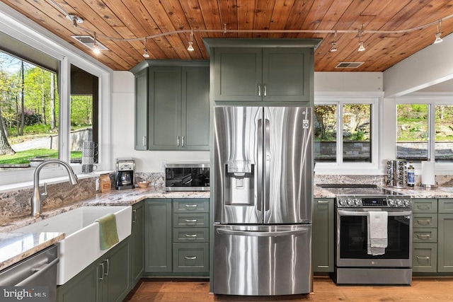 kitchen with appliances with stainless steel finishes, wood ceiling, sink, and light stone counters