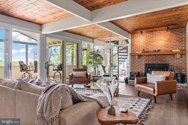 living room featuring a brick fireplace, hardwood / wood-style floors, beam ceiling, track lighting, and french doors