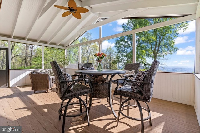 sunroom / solarium with ceiling fan and vaulted ceiling with beams