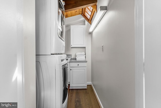 washroom with cabinets, stacked washer / drying machine, and dark hardwood / wood-style floors