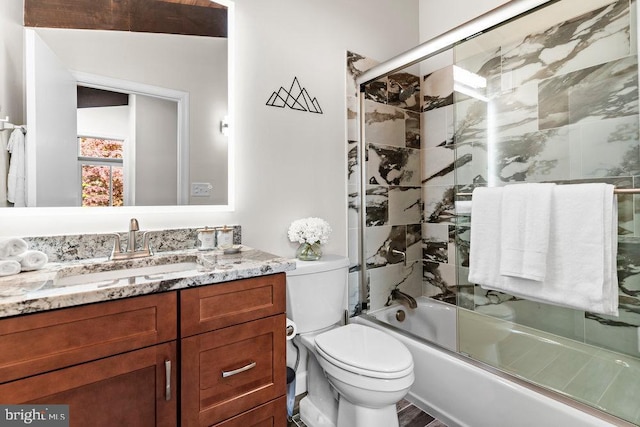 full bathroom featuring toilet, enclosed tub / shower combo, and vanity