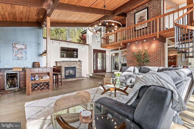 living room featuring hardwood / wood-style floors, beverage cooler, a fireplace, high vaulted ceiling, and wooden ceiling