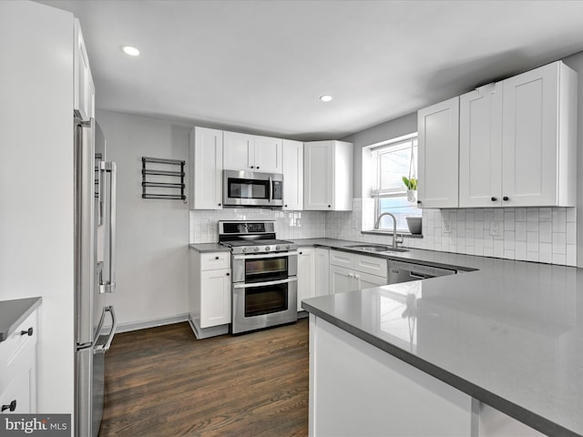 kitchen featuring white cabinets, stainless steel appliances, dark wood-type flooring, and sink