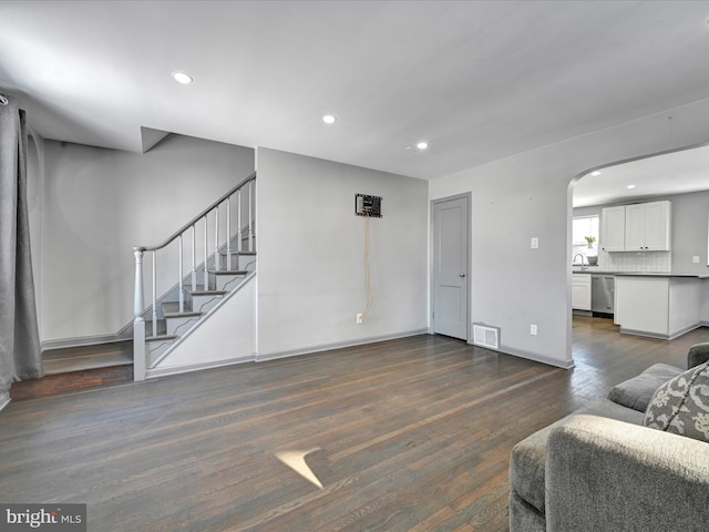 living room featuring dark wood-type flooring and sink