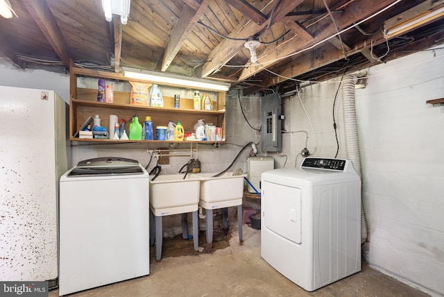 clothes washing area with washing machine and clothes dryer, sink, and electric panel