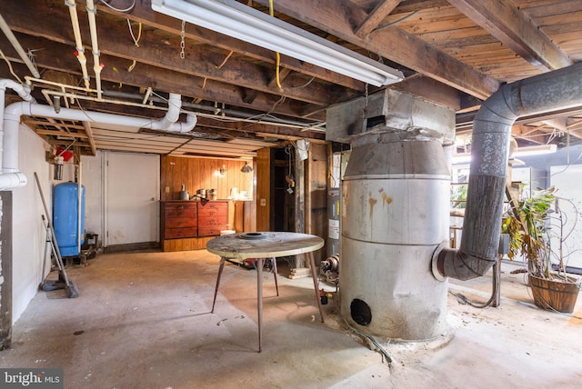 basement featuring wooden walls and water heater