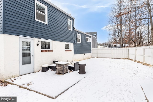 view of snow covered back of property